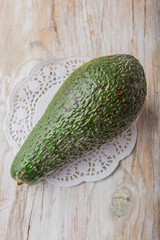Green avocado on a white wooden table