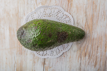 Green avocado on a white wooden table