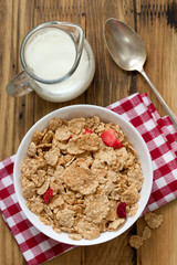 cereals with dry fruits in white bowl, milk and spoon