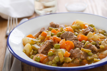 meat with carrot, peas and potato on plate