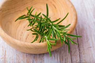 Branch of fresh rosemary on a white wooden