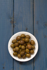 olives in white dish on blue background