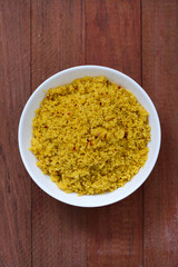couscous in white bowl on brown background