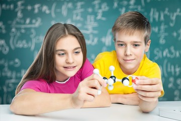 Academic. Teenage schoolchildren examining molecular structure
