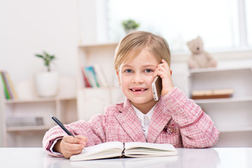 Little cute girl playing role of business woman