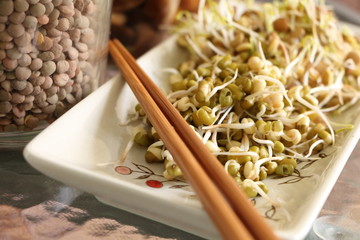 Lentil and mung beans sprouts salad on plate with chopsticks