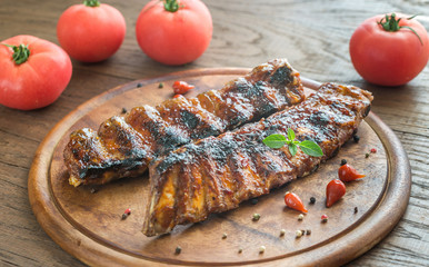 Grilled pork ribs with tomatoes on the wooden board