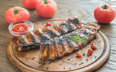 Grilled pork ribs with tomatoes on the wooden board