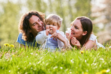 Junge Familie gemeinsam im Gras auf der Wiese