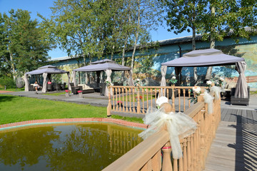 Landscaping with the wooden bridge, a reservoir and arbors tents