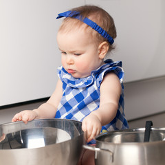 Little cute girl playing in kitchen