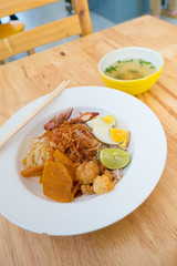 Asian dry noodle with garnish on the wooden background