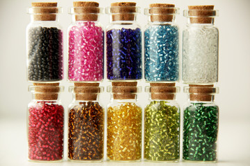 Tiny glass bottles filled with a different colors of beads