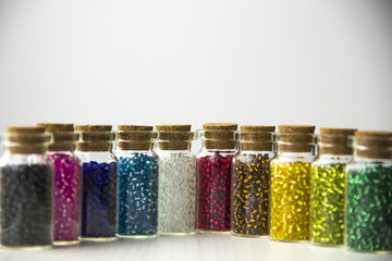 Tiny glass bottles filled with beads of different colors