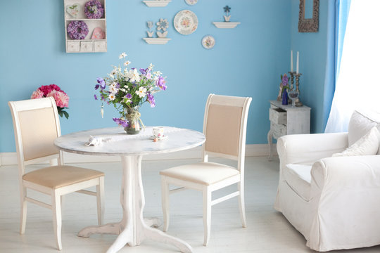 dining room interior with flowers decorative plates blue wall an