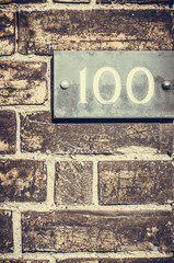 House number hudred on a brick wall.