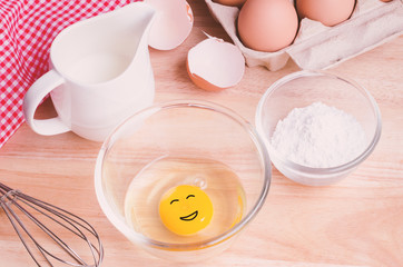 Cookies ingredients. Egg with smiling face in bowl, flour, milk