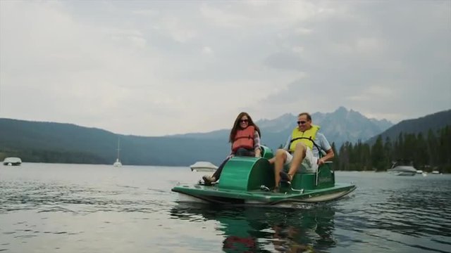 Medium shot of couple in pedal boat on lake / Redfish Lake, Idaho, United States