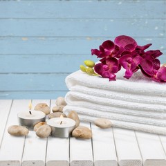 Fototapeta na wymiar Spa Treatment. Gladiola, towel, candles and river stones