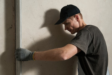 Woker fixes a guide to align the walls with stucco