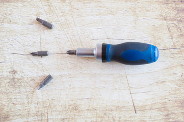 Used screwdriver heads isolated on wooden background