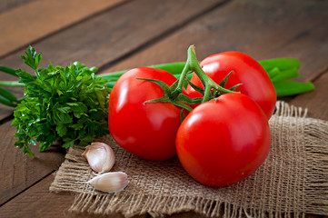 Branch of fresh tomato on wooden background