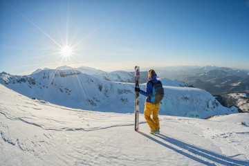 Fototapeta na wymiar skier looking at the sunset from the top of the mountain