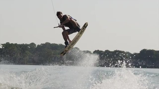 USA, Florida, Orlando, Maitland Lake, Young man doing trick on wakeboard