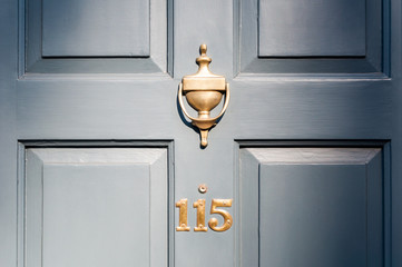 Obraz premium Door number one hundred and fifteen and knocker vignette look
