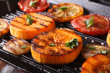 Grilled pumpkin and vegetables on grill pan. Horizontal macro
