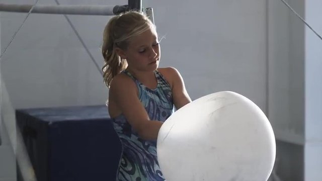 MS Girl (10-11) powdering hands in gym, Orem, Utah, USA