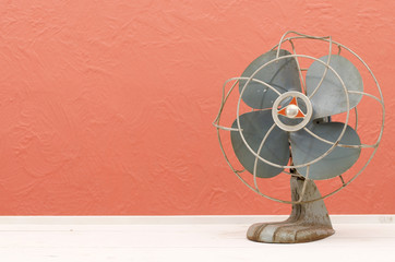 Fototapeta Vintage old fan on white table with pink, coral background wall obraz