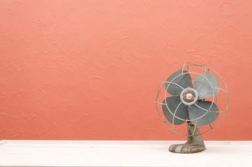 Vintage fan against a coral, pink wall
