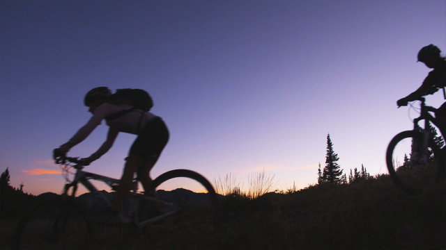 mountain bikers riding at sunset