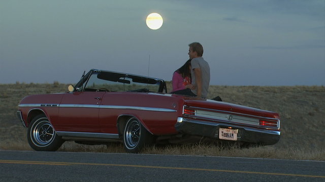 couple on the side of the road in a convertible