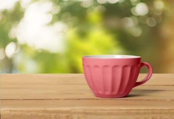 Abstract. Red cup with dots on wooden table over grunge