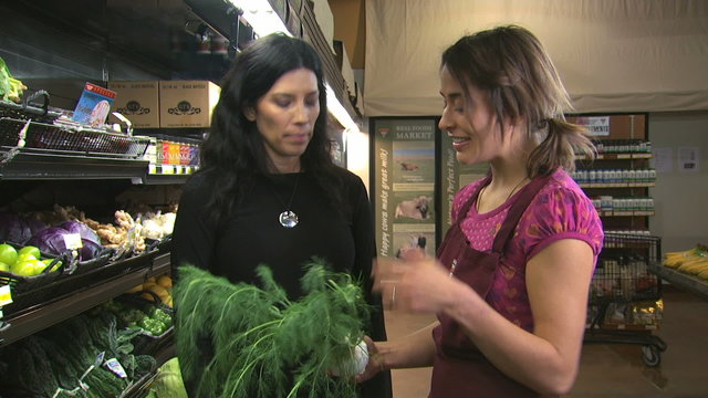 grocery clerk helping a woman with organic produce