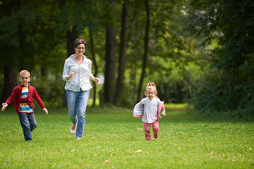 Naklejka na ściany i meble happy family playing together outdoor in park