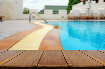 Wood Table Outdoor With Blurred Swimmimg Pool Background.