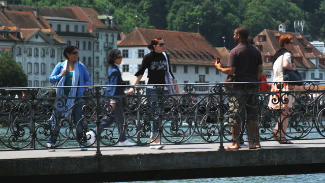 couple taking a photo of themselves on a bridge when a passerby stops to take it for them
