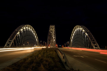 Obraz premium Street View of Cars Crossing a Bridge at Night