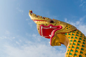 Naklejka premium serpent king or king of naga statue in thai temple on blue sky b