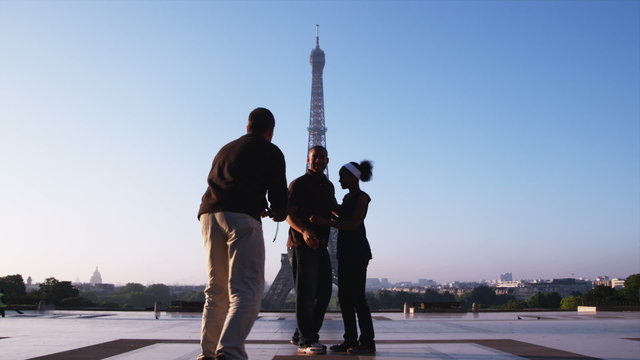 couple asking a man to take their photo in front of the Eiffel tower