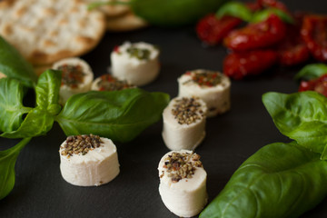 Obraz na płótnie Canvas crackers with goat cheese, sun-dried tomatoes and basil