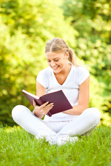 Young woman reading book in park