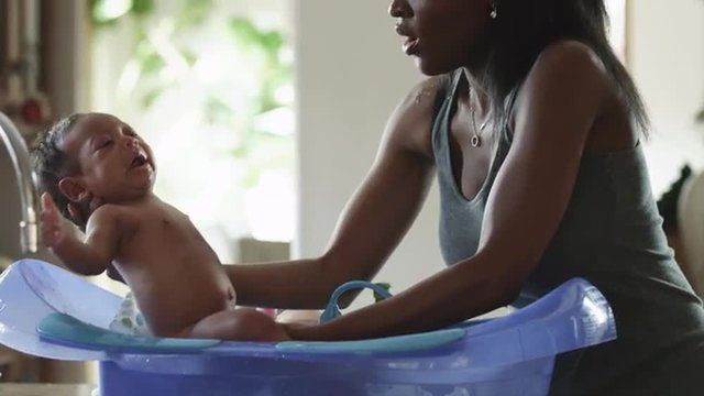 MS Woman washing baby boy (2-5 months) in bathtub / Cedar Hills, Utah, USA