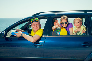 Father with two kids travel by car on sea vacation