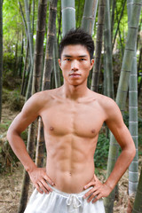 sport model -Yong muscular man in exercise outdoors. at nature forest over mountain 