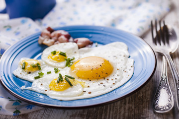 fried eggs with bacon in a plate