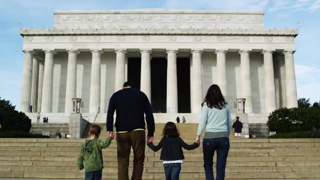 WS Rear view of family with two children (4-5, 6-7) ascending steps at Abraham Lincoln Memorial , Washington D.C, USA